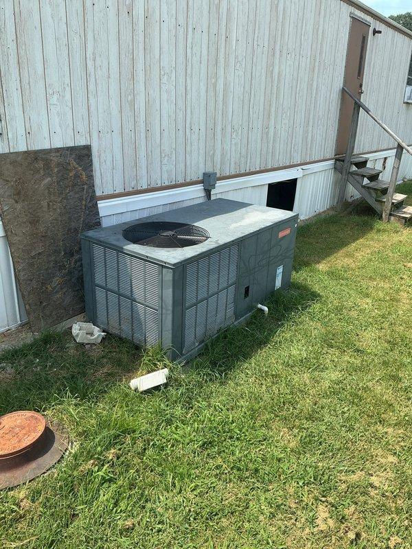 Responded to no-cooling call at residential property with aging package unit system. Upon arrival, found outdoor HVAC unit in weathered condition with legacy thermostat controls inside the home. Evaluated system for new homeowner experiencing complete HVAC failure, with both heating and cooling functions non-operational. Performed diagnostic assessment of package unit and thermostat wiring to determine operational status and recommended next steps for restoring climate control functionality to the property.