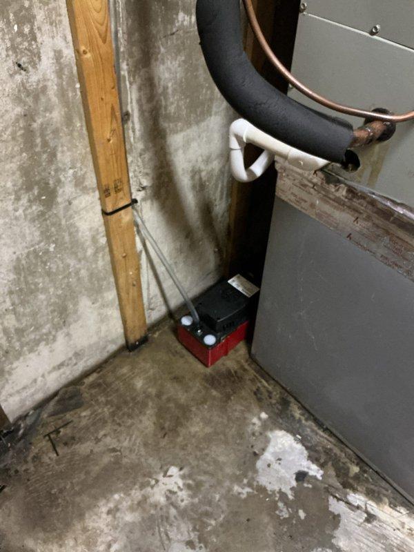 Responded to water leak call in basement area. Upon arrival, inspected Trane HVAC system and located source of leak at condensate pump assembly. Condensate pump was failing to properly discharge water, causing overflow from the unit. Examined condensate drainage system including PVC piping configuration and copper line connections. Verified condensate trap was functioning but pump mechanism required attention. Documented equipment condition with photographs showing unit installation, piping arrangement, and pump location at base of system. No water damage was observed to surrounding concrete floor or walls at time of inspection. Provided assessment of condensate pump failure and recommended repair options to restore proper drainage function and prevent future water accumulation.