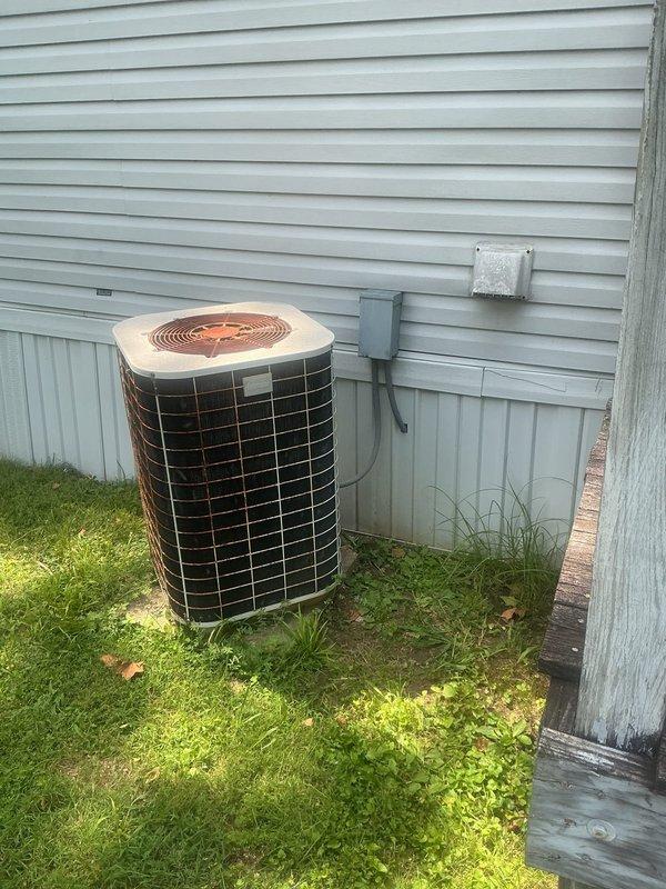 Responded to no cooling complaint on 30-year-old residential air conditioning system. Upon arrival, confirmed airflow present at vents with no ice buildup at indoor unit. Performed visual inspection of outdoor condenser unit and verified electrical connections at disconnect box. Inspected main electrical panel to confirm proper breaker operation and power supply to HVAC system. Documented equipment condition and installation configuration with exterior condenser unit positioned against vinyl siding with standard electrical conduit routing.