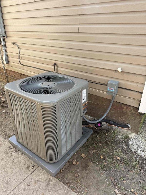# HVAC Complete System Installation

Successfully completed installation of a 4-ton, 17 SEER zoned HVAC system with 97% AFUE heating capability. The project included both indoor and outdoor equipment installation with proper refrigerant line routing and electrical connections.

## Indoor Installation

Installed air handler unit with metallic silver finish in utility area, positioned vertically against interior wall. Mounted large white pyramidal plenum chamber above air handler to facilitate proper airflow distribution throughout the ductwork system. Ran dual white PVC condensate drain lines vertically alongside equipment to ensure proper drainage and prevent water damage. Installed wall-mounted white rectangular air return vent for adequate system circulation.

Connected dark-colored heating unit with exposed copper refrigerant lines, properly insulated with black coating. Completed all electrical connections and verified proper component integration. Ensured all manufacturer labels a