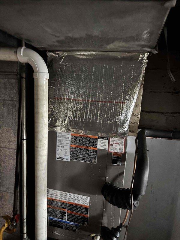 Responded to callback for recent HVAC installation experiencing condensation issues and steady dripping around furnace. Upon arrival, discovered severe ice and frost buildup on upper portion of air handler unit, indicating restricted airflow causing evaporator coil to freeze. Inspected condensate drainage system including PVC piping and confirmed proper installation but identified airflow restriction as root cause of excessive condensation. Verified system was operational at 73 degrees but running inefficiently due to frozen coil. Documented conditions with photos showing extensive frost accumulation on top panel and edges of unit. Addressed airflow issue, allowed coil to thaw, and verified proper condensate drainage through existing PVC system to resolve dripping concern.