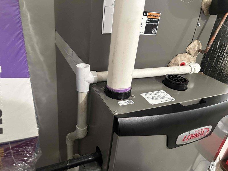 Responded to no cooling complaint on 2-year-old upstairs Lennox air handler. Upon inspection, found condensate drain pan flooded with standing water, causing float switch to activate and shut down system. Thermostat displayed 82°F with setpoint at 78°F. Diagnosed clogged condensate drain line preventing proper drainage. Cleared accessible portion of drain line and verified float switch operation. System requires proper Lennox drain trap component for complete repair to ensure proper condensate evacuation and prevent future shutdowns. Scheduled return visit with correct Lennox drain trap assembly to complete installation and restore full system operation.
