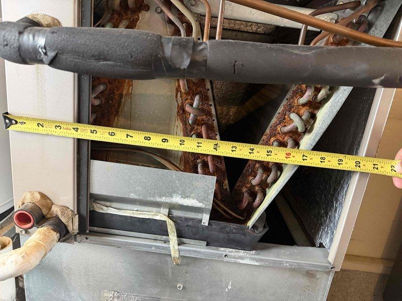Responded to no-cooling complaint on 15-year-old residential HVAC system with outdoor unit completely frozen and continuous runtime. Upon arrival, confirmed ice buildup on evaporator coil and indoor unit components. System was allowed adequate thaw time prior to diagnostic evaluation. Inspected indoor air handler, ductwork connections, and refrigerant lines for restrictions, leaks, and airflow issues. Observed rust deterioration on internal components and mounting hardware indicating age-related wear. Evaluated blower operation, filter condition, and return air pathways. Assessed refrigerant circuit for potential low charge or restriction causing freeze condition. Documented system condition with measurements and photographic evidence of internal components and overall installation.