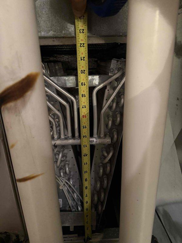 Responded to no cooling complaint on Carrier system less than 10 years old. Diagnosed failed evaporator coil in air handler unit located in utility closet. Documented coil dimensions and model information, captured photographs of failed component and system configuration for warranty claim processing. System currently non-operational; evaporator coil replacement required under warranty coverage with estimated half-day installation time upon part arrival.