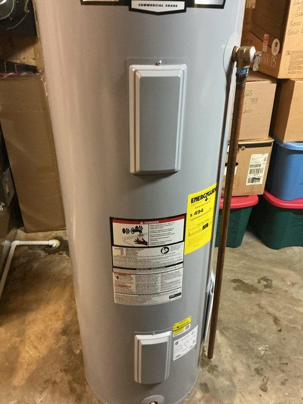 Completed installation of AO Smith ProLine commercial-grade electric water heater with 40-gallon capacity in basement utility area. Connected copper supply lines with brass fittings, installed hot and cold water connections with appropriate shut-off valves, and completed electrical wiring connections via flexible metal conduit. Unit properly positioned on concrete floor with all plumbing connections secured and tested for proper operation.