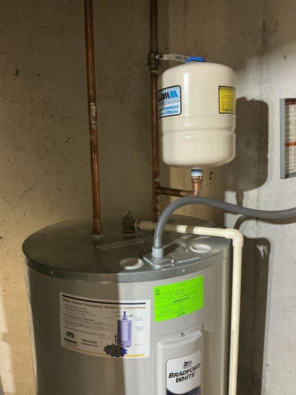 # Plumbing Maintenance - Tanked Water Heater Flush - A+

Performed routine maintenance flush on Bradford White tanked water heater system. Drained sediment and mineral buildup from tank bottom through drain valve to restore heating efficiency and extend equipment lifespan. Inspected all plumbing connections, copper supply lines, isolation valves, and expansion tank mounted above unit. Verified proper operation of green wheel-style shutoff valve and secondary valve controls. System refilled, tested for leaks, and confirmed proper pressure levels throughout hot water distribution system.