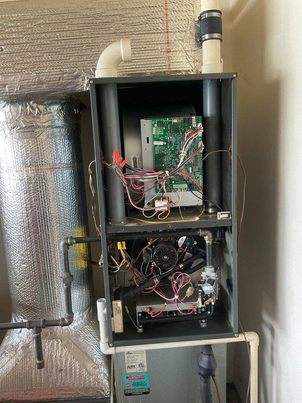 Completed scheduled planned duo maintenance on residential HVAC system including furnace and air conditioning components. Performed comprehensive inspection of all internal components with access panels removed, verified proper operation of blower motor assembly, examined control board and electrical connections for signs of wear or damage, and inspected heat exchanger condition. Checked all wire connections including multi-colored control wiring to circuit board and motor assembly, verified PVC condensate drain routing and secure mounting, and examined gas valve and mechanical fittings in lower compartment. Documented system condition through photographs showing internal components, wiring configurations, and overall unit integrity for maintenance records.