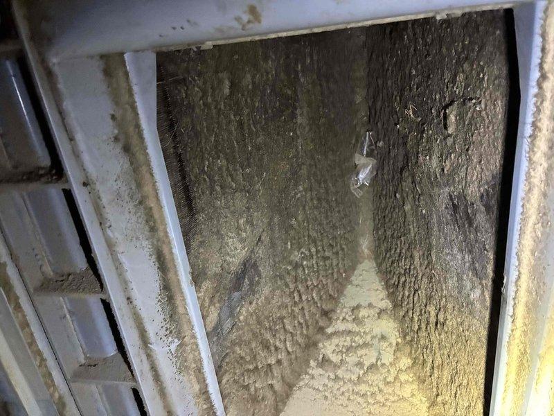 Responded to no cooling call on 6-year-old residential HVAC system with complete loss of function. Upon inspection, discovered severely restricted airflow due to extensive dust and debris accumulation throughout the air handler chamber and return air pathways. Identified clogged condensate drain line with standing water, indicating drainage system failure that likely contributed to system shutdown via safety float switch activation. Performed thorough cleaning of air handler interior, removed heavy particulate buildup from all surfaces, cleared condensate drain obstruction, and verified proper drainage flow. Tested system operation following service, confirmed restored airflow and normal cooling function, and recommended ongoing maintenance schedule to prevent future buildup and ensure optimal system performance.