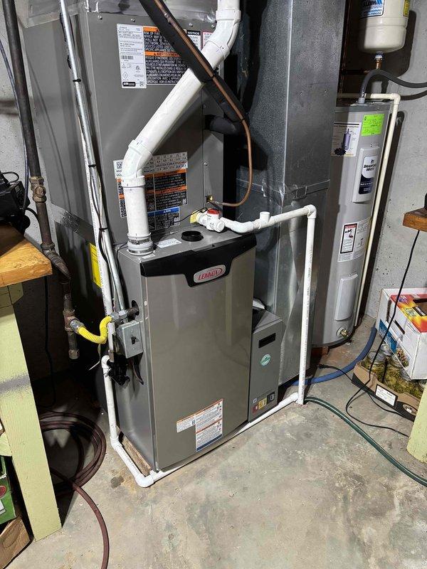Completed full HVAC system installation featuring a Lennox furnace configured as a 19 SEER/99% AFUE dual fuel system with LP conversion kit. Installation included proper venting with white PVC intake and exhaust piping, copper refrigerant line routing, gas line connection with shut-off valve, electrical connections, and integration with existing ductwork in mechanical room.