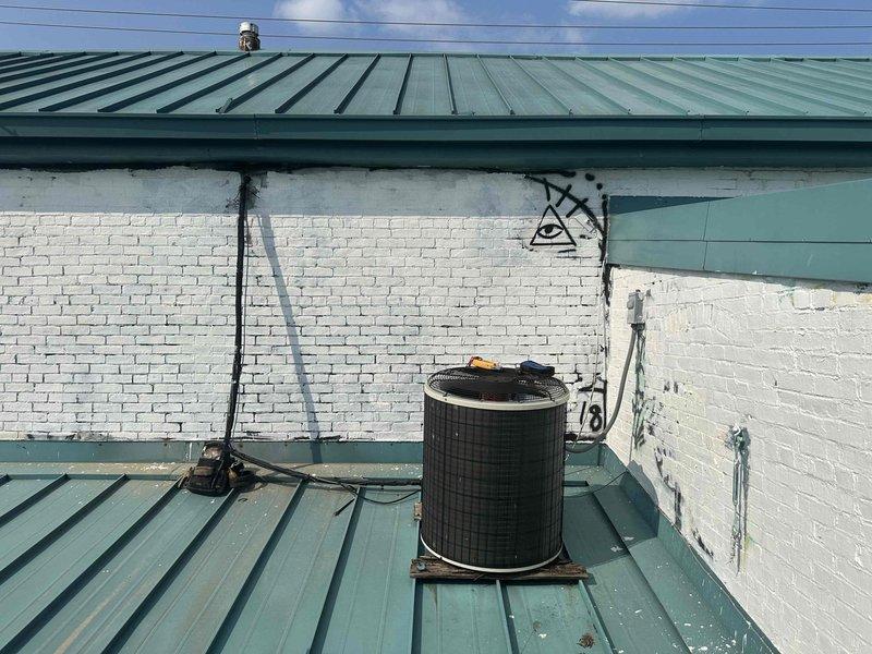 Responded to no-cooling call on property with two HVAC systems over 10 years old. Inspected rooftop condenser unit with non-operational outdoor fan and second system with reduced airflow performance. Evaluated both units for repair feasibility, documented equipment condition with photos showing rooftop installation and basement furnace/water heater setup. Provided system replacement options and water heater replacement quote as requested due to age and condition of existing equipment.
