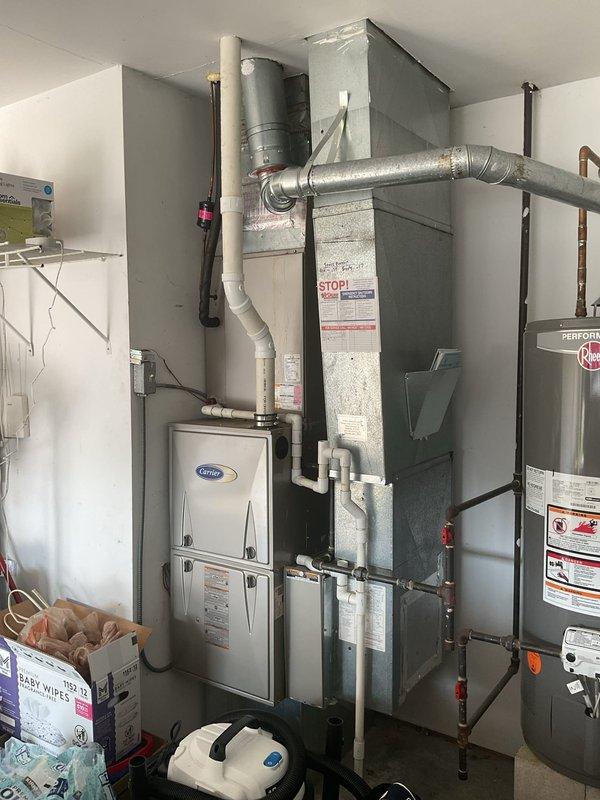 Completed comprehensive HVAC system replacement estimate for existing Carrier furnace installation in residential utility room. Evaluated current heating system configuration including ductwork connections, PVC venting system, and thermostat wiring to provide replacement options and specifications. Documented equipment specifications, spatial requirements, and existing infrastructure to prepare detailed proposal for new high-efficiency HVAC system installation.