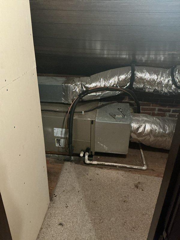 # Summary

Responded to no cooling complaint on 15-year-old residential HVAC system located in crawl space with air handler blowing but not producing cold air.

# Work Performed

Upon arrival, accessed air handling unit installed in confined crawl space area beneath residence. Unit appeared to be original equipment, approximately 15 years in service. Customer reported system was running and circulating air but failing to cool the living space.

Performed visual inspection of air handler and associated ductwork. Unit showed signs of age-appropriate wear with dusty conditions typical of crawl space installation. Verified blower operation - confirmed air handler was energized and moving air through the system as reported.

Inspected refrigerant line connections at air handler, noting black flexible refrigerant lines routing from unit. Examined condensate drain system with white PVC piping present and properly routed from unit base.

Assessed ductwork configuration including flexible silve
