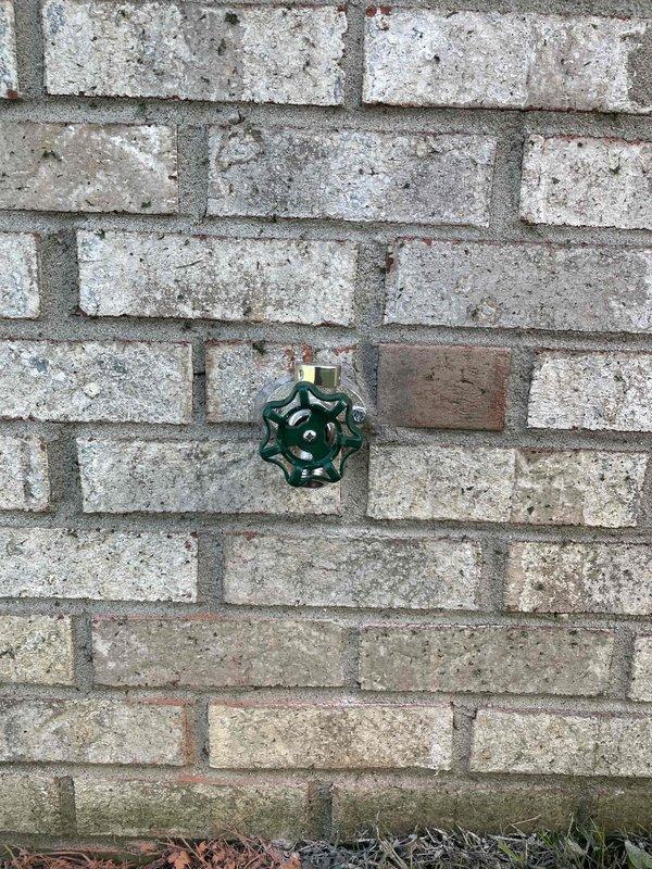 Upon arrival, identified a hose bib mounted on exterior brick wall with minor leakage at wall penetration point and evidence of previous water intrusion. Assessed interior access point and determined repair would require cutting into basement ceiling drywall, which was outside scope of work. Secured hose bib fixture directly to brick wall using anchoring hardware and applied silicone sealant around entire perimeter of wall penetration to prevent water infiltration and seal against environmental elements.