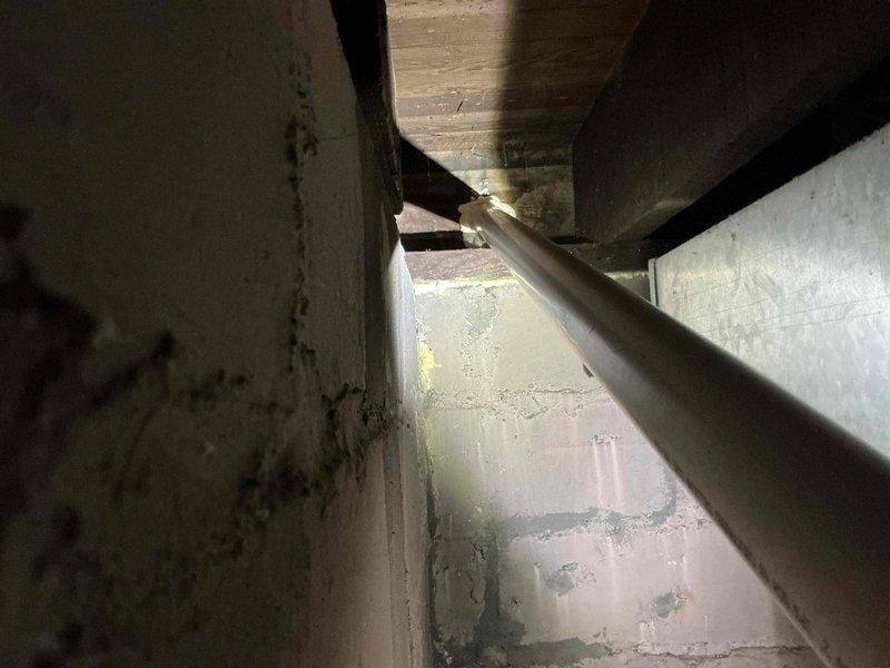 Conducted site assessment for ductwork insulation estimate in confined mechanical space. Documented existing conditions including uninsulated refrigerant lines, HVAC ductwork, and structural deterioration with moisture damage and staining on interior surfaces requiring attention prior to insulation installation.