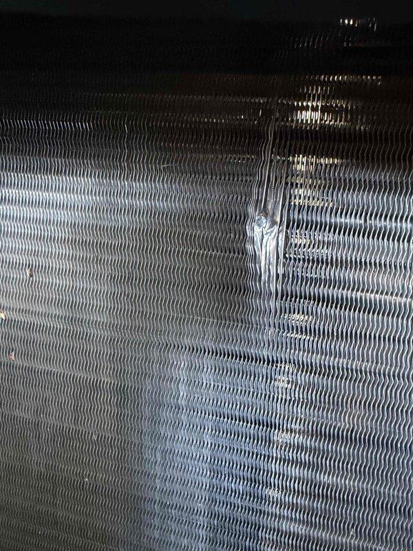 Responded to no-cooling call on 7-year-old residential system. Upon arrival, discovered fallen gutter had impacted outdoor condensing unit, causing physical damage to condenser coil with audible refrigerant leak (hissing sound). Inspected condenser coil fins and confirmed significant damage requiring coil replacement. Documented damage with photographs showing compromised coil structure. System currently non-operational due to refrigerant loss from damaged coil. Warranty condenser coil ordered for replacement; estimated half-day installation required upon part arrival. Customer advised system cannot operate until coil replacement completed. Payment arrangements coordinated through roofing company's card on file per customer authorization.