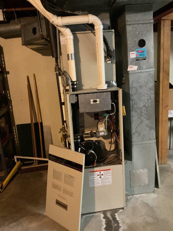 Completed first annual preventive maintenance visit for new Gold Level customer with single HVAC system aged 20+ years. Performed comprehensive inspection of indoor furnace unit located in basement mechanical room and outdoor condensing unit. Removed furnace access panel to inspect blower motor assembly, electrical connections, and internal components. Verified proper operation of all mechanical systems and examined PVC condensate drainage piping. Conducted exterior unit assessment including fan motor operation, condenser coil condition, and electrical disconnect functionality. Documented equipment condition through photographic record showing both indoor and outdoor units for service history reference.