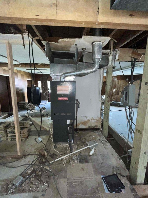 Conducted site assessment for furnace relocation project in unfinished basement area. Evaluated existing Goodman furnace unit and current ductwork configuration to provide estimate for relocating equipment and installing new duct system. Documented present conditions including exposed framing, concrete flooring, existing electrical routing, and accumulated debris in workspace. Assessed attic/crawl space areas with existing flexible ductwork and insulation to determine scope of modifications required for relocated furnace and new duct installation.