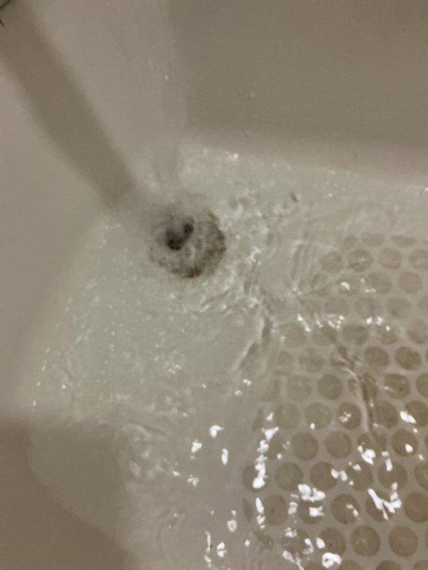 Responded to emergency call for active water leak in bathroom with water dripping onto light fixture below. Upon arrival, found leak originating from bathroom plumbing with water supply not shut off, creating potential safety hazard and ongoing property damage. Performed diagnostic inspection of bathtub area, identifying source of leak and assessing condition of existing plumbing fixtures including chrome spout, diverter valve, and drain assembly. Documented aging bathroom fixtures showing typical wear patterns, mineral deposits, and discoloration consistent with older plumbing systems. Shut off water supply to prevent further damage and completed assessment of affected areas to determine necessary repairs.