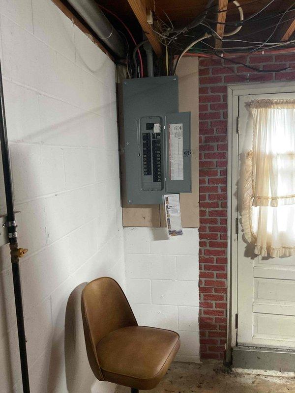Conducted comprehensive on-site electrical assessment for standby generator installation at residential property. Evaluated existing electrical infrastructure including main breaker panel located in basement utility area, documented current electrical service capacity and available circuit positions. Assessed natural gas supply system and metering equipment mounted on exterior brick wall to confirm adequate fuel source availability for generator operation. Photographed electrical panel configuration showing circuit breaker arrangement and conduit routing, as well as gas meter installation to determine proper tie-in points for generator fuel line connection. Verified compatibility of existing electrical service with proposed automatic transfer switch installation requirements and confirmed proper grounding provisions present at main panel location.