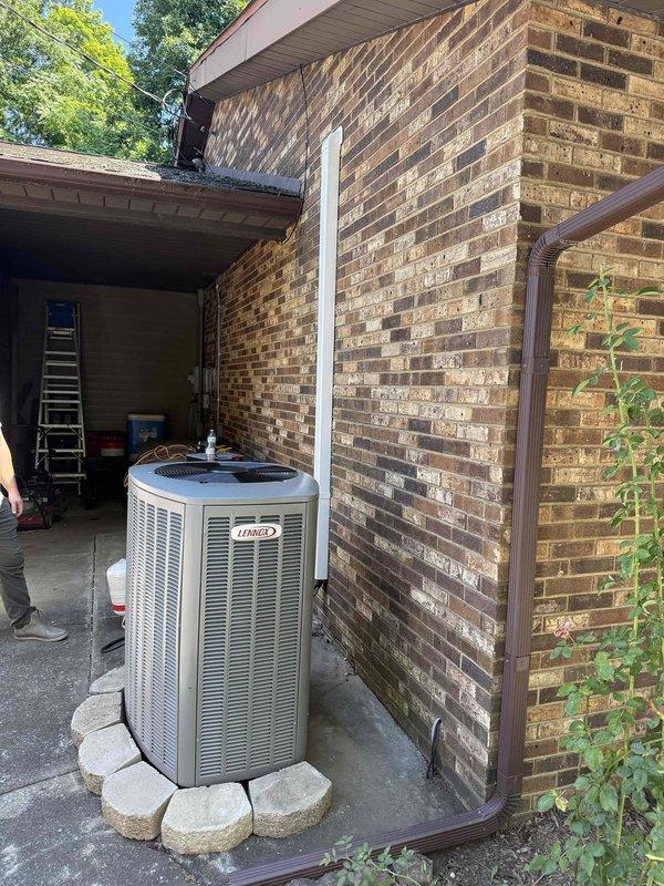 Completed installation of Lennox HVAC system at residential property. Unit was properly positioned on concrete pad with decorative landscaping blocks, refrigerant lines routed along exterior brick wall, and all connections secured. System was charged with R454B refrigerant and verified operational parameters using digital manifold gauges, confirming proper pressures and temperatures within manufacturer specifications.