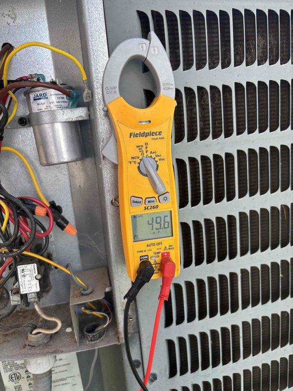Completed scheduled preventive maintenance on residential air conditioning system. Performed comprehensive AC tune-up including inspection of electrical components, contactors, and capacitor within control panel. Verified system operation with amperage readings at 49.8 amps using digital multimeter. All electrical connections tested and found secure, though control panel showed normal weathering consistent with outdoor installation. System operating within manufacturer specifications with no issues identified or repairs required at time of service.