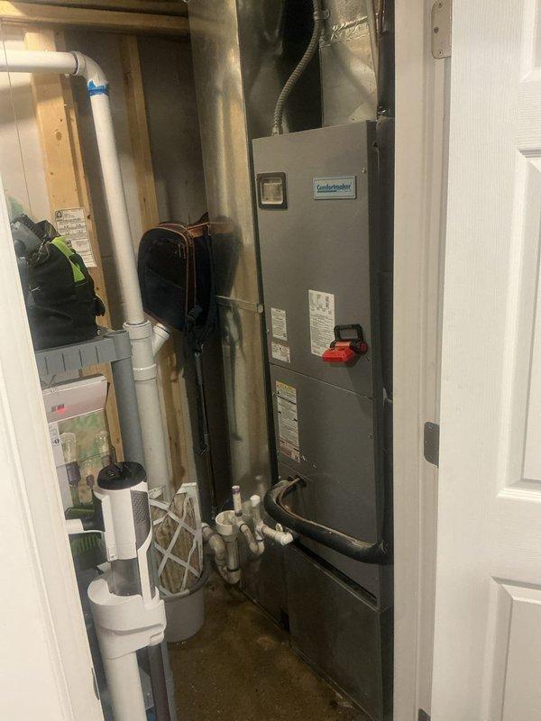 Responded to water leak complaint at residential property with 8-year-old Comfortmaker air handler system located in utility closet. Upon arrival, found active water dripping from condensate drain line with bucket placed underneath to collect discharge. Customer reported leak began previous day and continued even after shutting down air conditioning system to prevent condensation buildup. 

Performed diagnostic inspection of air handler unit and condensate drainage system. Inspected PVC condensate drain piping, drain pan, and associated plumbing components. Evaluated condensate pump operation and drain line routing. Checked for blockages in primary and secondary drain lines. Assessed air handler cabinet for proper seal and insulation to rule out external condensation issues.

Identified source of leak and cleared blockage from condensate drain system. Verified proper drainage flow and tested system operation. Confirmed no water damage occurred to surrounding areas or flooring. Document