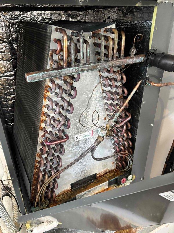 Completed second annual Platinum Level planned maintenance on dual HVAC system with 4-year-old units utilizing 20x25x5 and 16x25x5 filters. Performed comprehensive inspection of both systems, including evaporator coil assemblies, electrical connections, and refrigerant lines. Documented significant copper coil oxidation and corrosion throughout both evaporator sections, with heavy discoloration concentrated on lower coil portions indicating prolonged moisture exposure. Inspected all electrical wiring, thermostat connections, and control components for proper operation. Verified integrity of refrigerant lines, connection ports, and service valves. Noted extensive rust formation on metal coil elements and surrounding components, suggesting ongoing condensation issues requiring monitoring. Checked condensate drainage system and mounting brackets for structural integrity. All functional components including motors, capacitors, and connection fittings remain operational despite visible age-