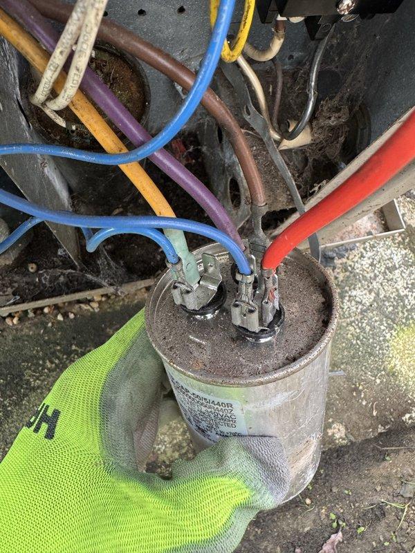 Performed diagnostic on AC system that was blowing air but not cooling. Inspected capacitor and compressor electrical connections, finding multiple wires with visible wear. Identified capacitor failure as the source of cooling issue and replaced component to restore proper system operation.