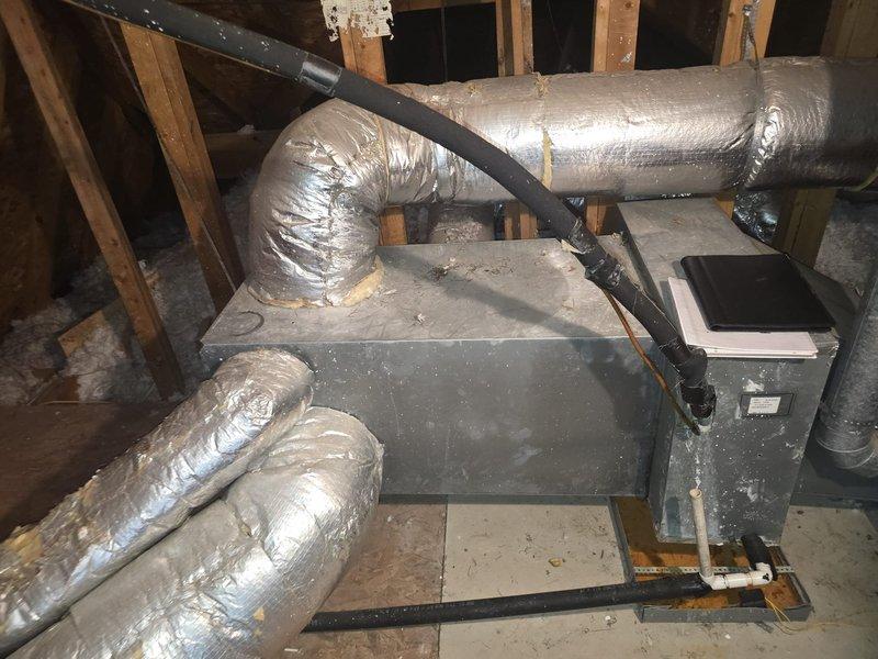 Conducted a comprehensive evaluation of two HVAC systems requiring replacement - a 25-year-old 2-ton unit serving the upstairs area and a 4-ton unit for downstairs. Both systems remain operational but are at end of life. Assessment included inspection of the existing attic air handler installation, associated ductwork with reflective foil insulation, and examination of the confined wall cavity containing various mechanical components including insulated piping and galvanized ductwork. Documentation was prepared for potential property transaction negotiations.