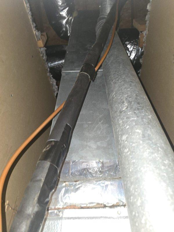 Conducted a comprehensive evaluation of two HVAC systems requiring replacement - a 25-year-old 2-ton unit serving the upstairs area and a 4-ton unit for downstairs. Both systems remain operational but are at end of life. Assessment included inspection of the existing attic air handler installation, associated ductwork with reflective foil insulation, and examination of the confined wall cavity containing various mechanical components including insulated piping and galvanized ductwork. Documentation was prepared for potential property transaction negotiations.