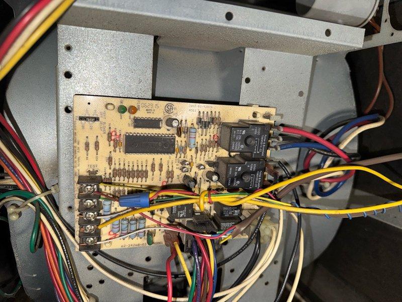 Performed pre-purchase HVAC inspection on two residential units. Inspection revealed normal operational condition of control circuit board with proper wire connections and no visible damage to electronic components. However, discovered moisture damage and possible mold growth at system corner junction where insulation meets metal flashing, with evidence of deterioration and compression of the pink insulation material.