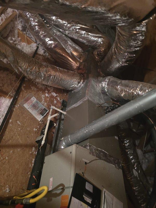 Completed comprehensive assessment of residential attic HVAC system installation. Documented existing air handling unit, flexible ductwork routing, and associated components including metallic piping, electrical conduit, and drainage lines positioned within confined crawl space between wooden joists and insulation.