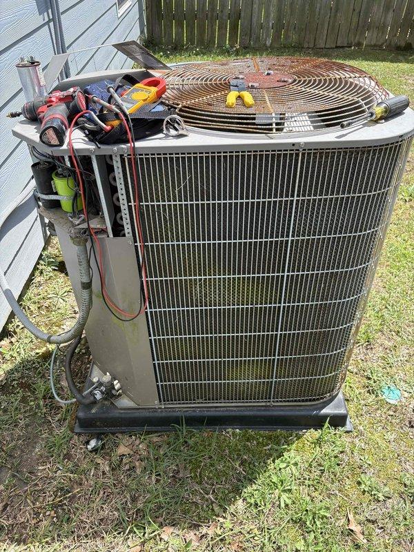 # Diagnostic - AC Issue

Responded to no cooling complaint on upstairs unit in two-system home. Upon arrival, confirmed compressor was running but condenser fan motor failed to operate. Removed access panel and performed electrical diagnostics on outdoor unit. Testing revealed faulty fan motor and defective capacitor preventing fan operation. Documented unit condition with photos showing internal electrical components, capacitor, and refrigerant lines. Provided customer with repair recommendations for fan motor replacement and capacitor replacement to restore cooling functionality to upstairs system.