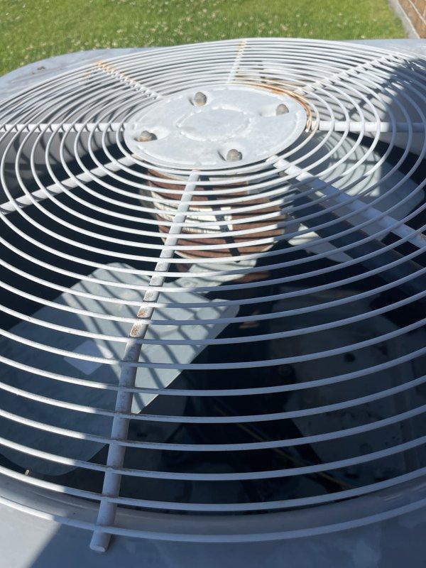 Completed spring maintenance on residential air conditioning system. Inspected outdoor condenser unit including fan assembly and protective guard, performed standard seasonal preventive maintenance procedures, and tested system capacitor using digital meter to verify proper electrical function and ensure optimal system performance for the cooling season.