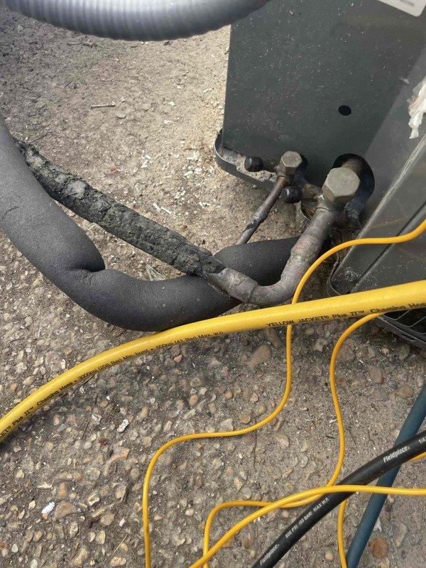 Responded to report of AC line freezing up and unit being inoperable. Upon arrival, unit was off and defrosted as indicated. Conducted diagnostic inspection of system components, including interior evaporator assembly and exterior rooftop equipment. Inspection revealed significant corrosion and deterioration on drainage pan with visible rust spots, mineral deposits, and sediment accumulation indicating chronic moisture exposure and potential drainage issues. Documented condition of condensate management system showing signs of long-term water pooling. Examined exterior rooftop unit connections, refrigerant lines, and electrical components. Black insulated refrigerant line showed age-related wear. Metal fittings and connections displayed weathering and surface corrosion consistent with outdoor exposure. Photographed affected components for documentation purposes. Freeze-up condition likely related to compromised drainage system preventing proper condensate removal, leading to ice format