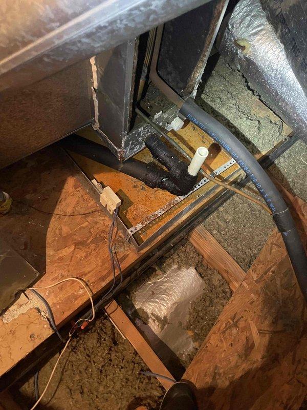 Completed spring maintenance inspection on residential HVAC system. Accessed attic-mounted air handler unit and inspected ductwork, connections, and overall system condition. Identified significant corrosion and deterioration on mechanical components requiring attention. Documented system condition with photographs showing flex ductwork routing, insulated supply lines, and corroded metal housing with visible surface cracks and oxidation around mounting points.