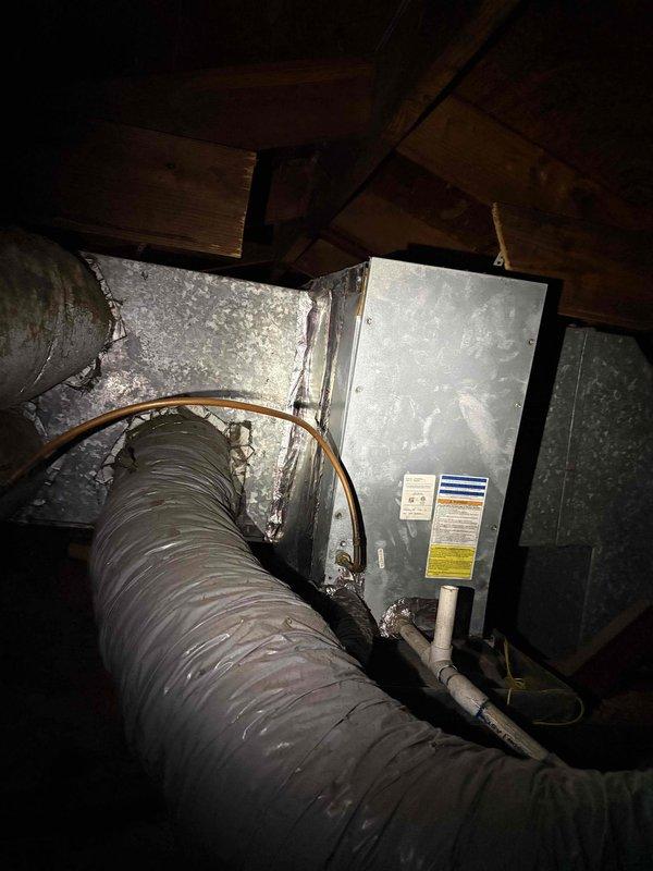 Completed return visit to vacant property following resolution of electrical issues. Replaced Schrader valve at evaporator coil, removed and replaced all deteriorated ductwork throughout attic space, and installed new 8" drop duct to service additional room. Verified evaporator coil is properly leveled and draining correctly to prevent future condensate issues.