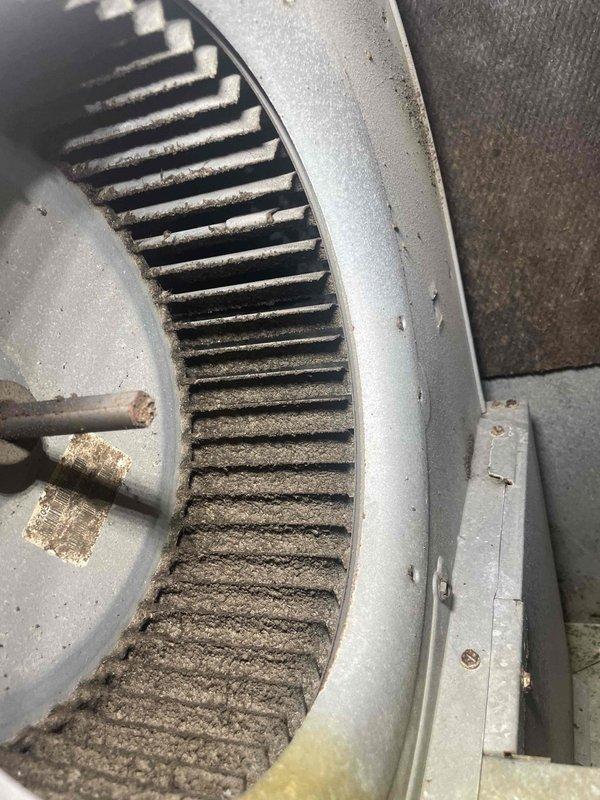 Responded to service call for electric AC unit experiencing freeze-up issues while still maintaining cooling capacity. Upon inspection, discovered heavily restricted airflow due to excessive dust and debris accumulation on the blower wheel assembly and interior components. The blower wheel blades exhibited significant matting of dust buildup, severely impacting system performance and causing the evaporator coil to ice over. Customer had turned unit off approximately two hours prior to allow defrosting. Documented condition of contaminated blower assembly and interior surfaces for service records. Recommended thorough cleaning of blower wheel, evaporator coil inspection once fully defrosted, and air filter evaluation to restore proper airflow and prevent future freeze-up conditions.