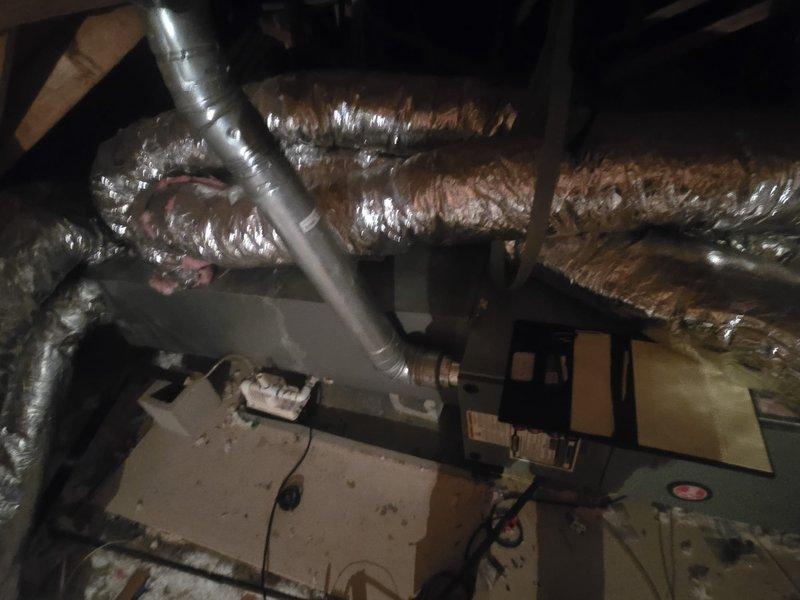 Conducted comprehensive assessment of existing HVAC system located in attic space. Evaluated current air handler unit, ductwork configuration, and overall system condition. Documented deteriorating flexible ductwork with compromised outer coverings exposing internal insulation, multiple branch connections showing wear and discoloration, and equipment positioning on platform. Provided detailed estimate for complete system replacement including new air handler installation and ductwork modifications to address observed deficiencies and improve system performance.