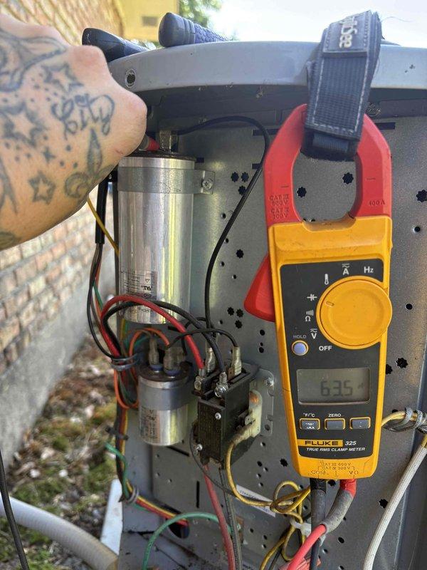 Completed comprehensive AC maintenance inspection on single residential system. Performed electrical diagnostics using clamp meter to verify capacitor performance and amperage readings, measuring 6.35 amps on compressor circuit. Removed and cleaned outdoor unit condenser coil and grille assembly, which showed moderate weathering and soiling accumulation. Documented system specifications and current operating conditions with detailed photographs for membership service records.