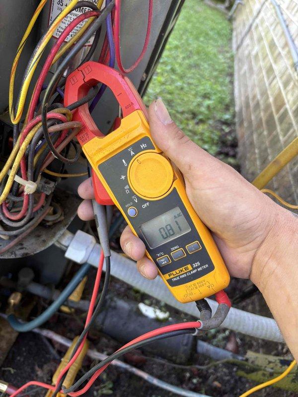 Completed spring maintenance on split system air conditioning unit at rental property. Performed comprehensive system inspection with indoor unit from 2019 and older outdoor unit. Utilized Fluke clamp meter to measure electrical current draw and voltage at outdoor condensing unit, verifying amperage readings and system electrical performance within manufacturer specifications at 233 volts. All electrical connections inspected and found secure with proper wire routing observed at disconnect box.