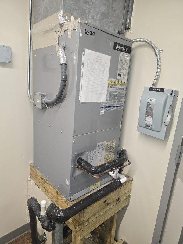 Conducted estimate for 1-ton HVAC system replacement. Documented existing Ameristar air handler unit with associated ductwork, refrigerant lines, and condensate drainage system. Noted deteriorated metal panel with visible rust and corrosion marked for replacement, along with aging ductwork requiring attention in kitchen area.