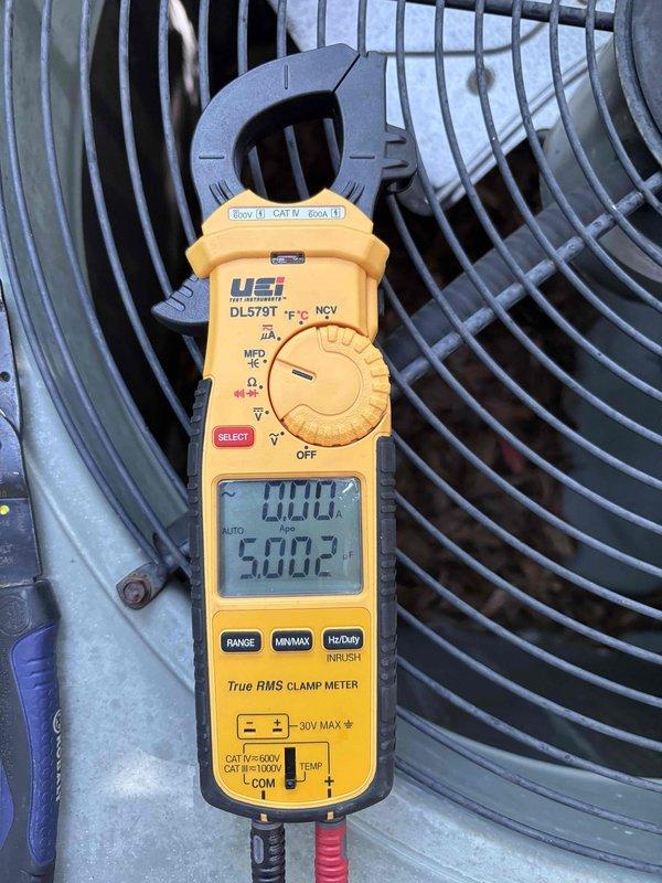 Responded to no cooling complaint on 2008 electric air conditioning system with gas heat. Customer reported thermostat displaying 77°F while set to 74°F, system blowing air but not cooling adequately, and drain pan overflow issues occurring intermittently over past two weeks. Upon arrival, system was turned off with thermostat fan set to ON per dispatch instructions.

Performed diagnostic evaluation of outdoor condensing unit and indoor evaporator coil assembly. Measured electrical parameters at condenser unit using clamp meter, recording 188.8 voltage and 50.02 Hz frequency, indicating proper power supply to equipment. Inspected outdoor unit fan motor operation and compressor function.

Conducted thorough inspection of indoor evaporator coil assembly, revealing extensive corrosion and rust deterioration on copper refrigerant lines and metal support components. Coil showed significant aging consistent with 16-year-old equipment, with visible oxidation on tubing and structural elements.