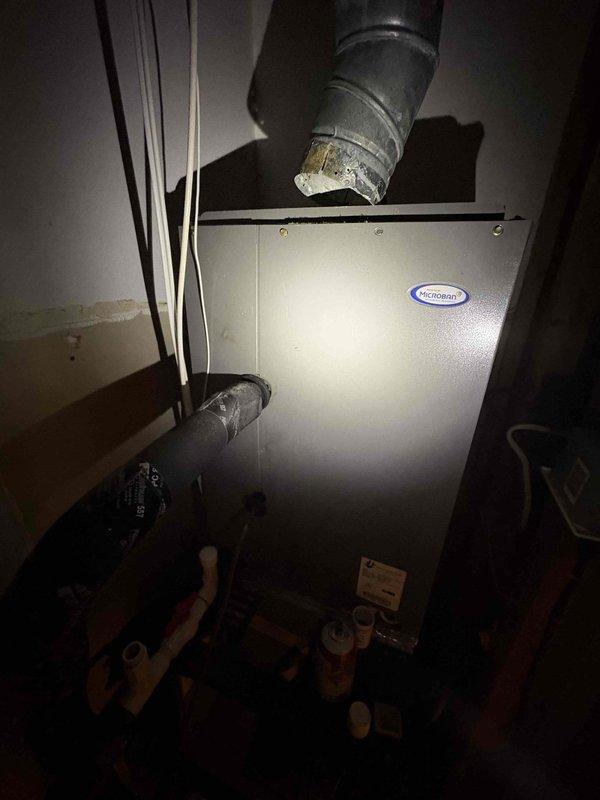 Responded to service call for AC unit experiencing short cycling issues. Performed diagnostic inspection of HVAC system, measuring supply air temperature at floor register (60.2°F) and inspecting air handler unit with connected ductwork and refrigerant lines. Documented system condition including deteriorated duct insulation at connection points and overall equipment configuration for further evaluation and repair recommendations.