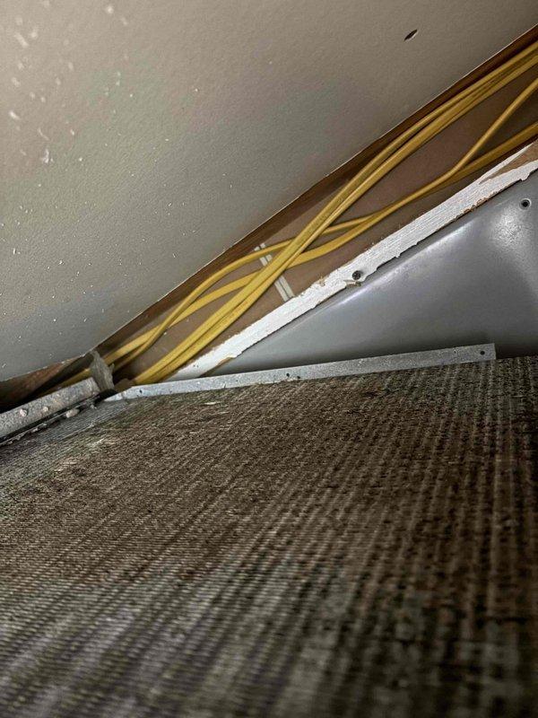 Responded to service call for HVAC system running continuously without reaching thermostat setpoint. Performed diagnostic inspection of air handler unit and evaporator coil assembly. Upon visual examination, identified discoloration and potential contamination on evaporator coil fins indicating restricted airflow or refrigerant system issues. Inspected refrigerant line connections and copper tubing routing at air handler. Documented equipment condition with photographs for customer records and recommended further evaluation of system performance and coil cleaning or replacement to restore proper cooling capacity.