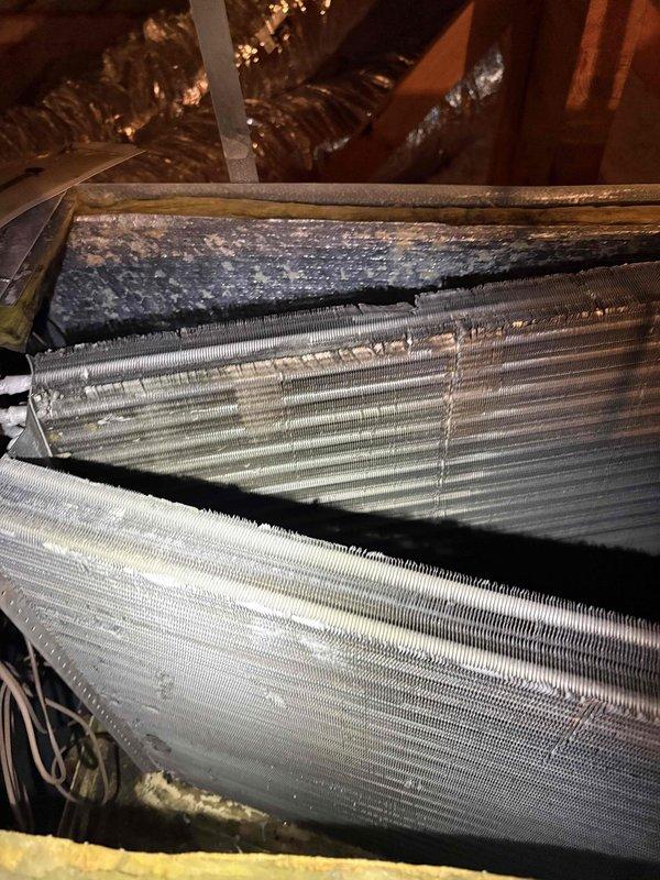 Completed spring maintenance on residential AC system. Upon inspection, found evaporator coil heavily coated with dust and debris accumulation throughout all fin sections, which was causing restricted airflow and contributing to the extended cooling times reported by customer. Performed thorough cleaning of evaporator coil, removing significant buildup from aluminum fins and housing. Verified proper refrigerant line connections and inspected all accessible system components in attic installation. System airflow restored to proper levels following coil cleaning, which should resolve the delayed temperature recovery issue.