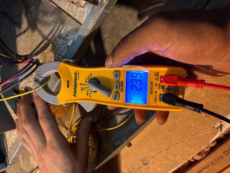 Completed scheduled late evening inspection on 3-ton R22 air conditioning system with focus on refrigerant level verification as requested. Performed electrical diagnostics using clamp meter, obtaining amperage readings on system components. Inspected contactor assembly and associated wiring connections, noting age-related wear on wire insulation and terminal connections. System evaluated and measurements documented for customer review.