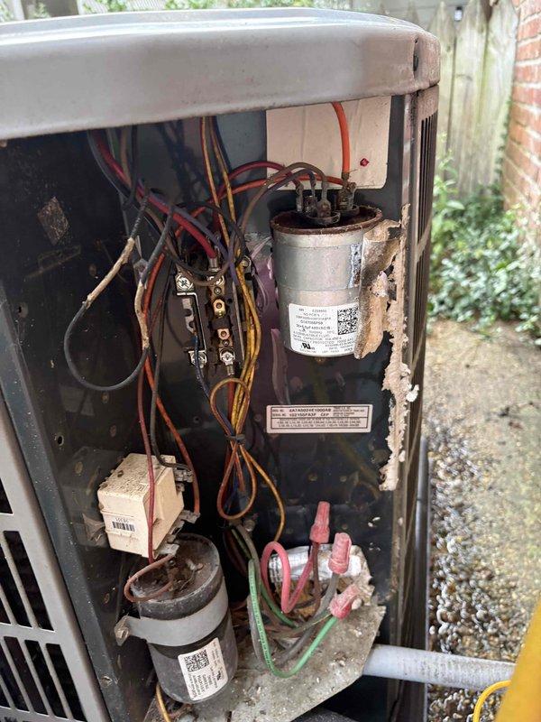 Responded to no cooling complaint on kitchen area unit while main system replacement is pending with two temporary units operating. Upon arrival, confirmed indoor unit running and compressor operational but no cool air delivery. Inspected condensate pan and verified no water present. Removed outdoor unit access panel and performed diagnostic evaluation of electrical components including dual capacitors and wiring connections. Utilized Elitech LMC-100A+ diagnostic meter to test system performance and electrical values. Documented equipment condition with photos showing capacitor assembly, electrical connections with multiple wire colors, terminal blocks, and overall component layout. Unit shows signs of age with interior weathering and dirt accumulation noted during inspection.