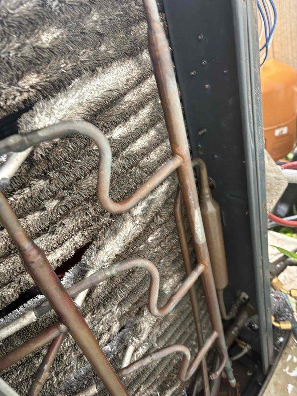 Responded to no-cooling call and performed diagnostic on HVAC system. Found evaporator coil completely frozen with extensive ice crystal formation and heavy dust/debris accumulation restricting airflow. Indoor blower motor operating but outdoor unit not running, resulting in warm air discharge. Advised shutting down compressor while leaving fan in continuous operation to facilitate ice melting and prevent further damage. Documented coil conditions with photos showing severe frost buildup and maintenance neglect. System requires follow-up service for coil cleaning, refrigerant charge verification, and potential component replacement once ice has melted.