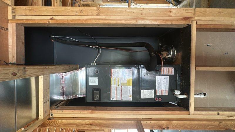 Completed installation of HVAC system including air handler unit and outdoor condensing unit. Air handler was properly mounted within framed interior space with connections made to flexible ductwork and rigid duct piping. Exterior condenser unit was installed on building exterior with appropriate electrical disconnect and protective grille. All ductwork connections were secured and system was prepared for final startup and commissioning.